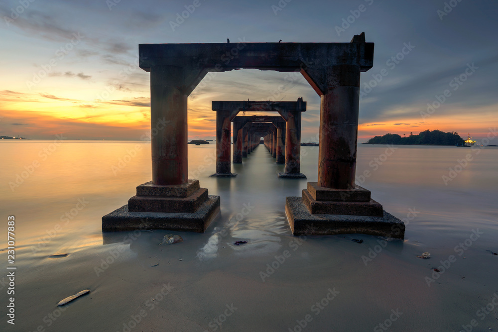 A long Exposure Picture Of abandoned old jetty with  beautiful sunrise as background