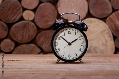The Classic Black Alarm clock over wooden background
