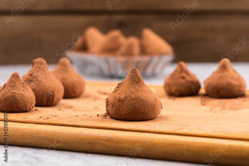 Chocolate truffles laid out on a wooden Board.
