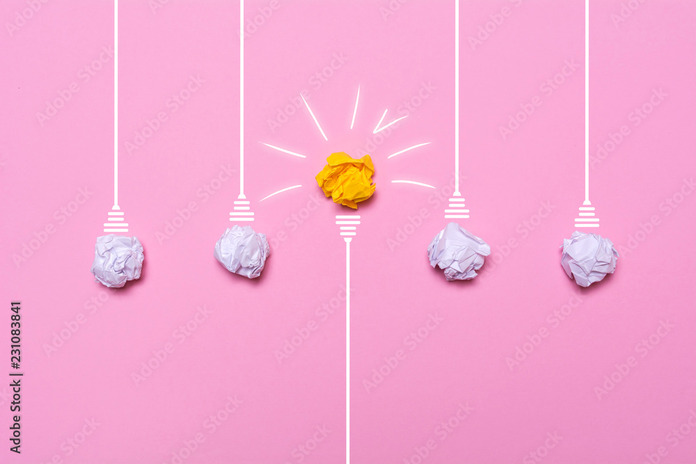 Creative idea of crumpled paper. A burning light bulb on a pink background - obrazy, fototapety, plakaty 