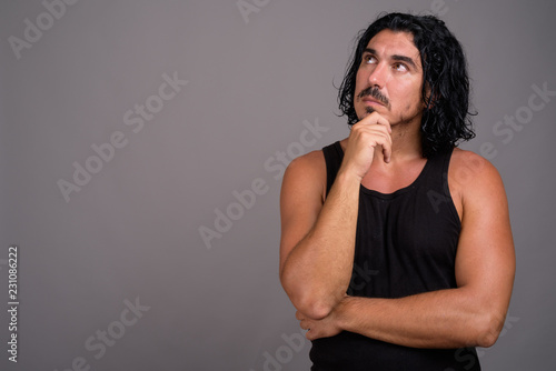 Handsome macho man with mustache against gray background © Ranta Images