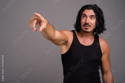 Handsome macho man with mustache against gray background