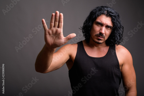 Handsome macho man with mustache against gray background