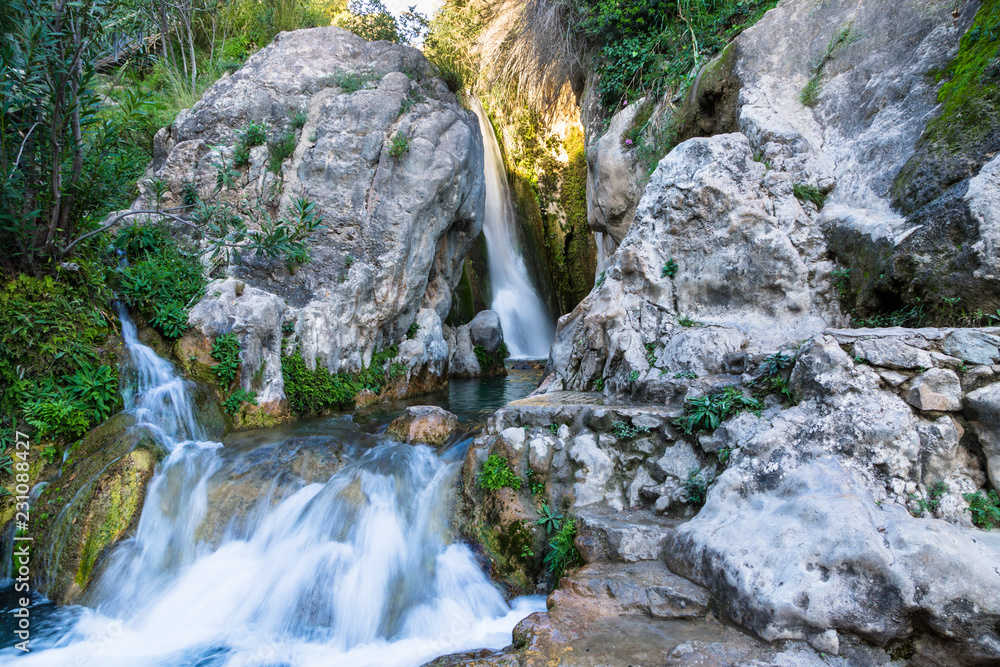 Fototapeta premium Wonderful waterfall between solid rocks in a natural pond. Fuentes del Algar Costa blanca spain - Alicante Benidorm