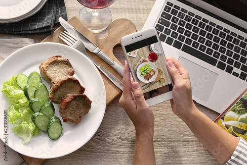 Blogger taking photo of food with mobile phone, closeup