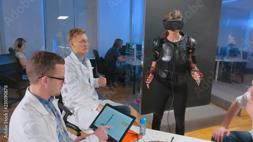 A woman checks a droid, wearing VR glasses. Virtual reality concept.