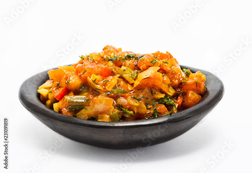 Traditional Colombian sauce called hogao served in a black ceramic dish isolated on white background