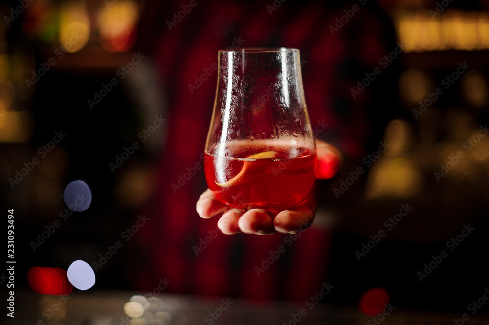 Bartender serving glass of a Sazerac cocktail