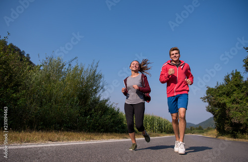 young couple jogging along a country road