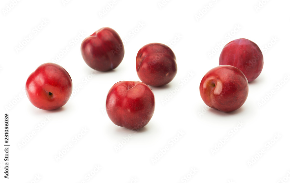 Fresh harvested red ripe plums, isolated on white. Five shiny red plums on white surface.