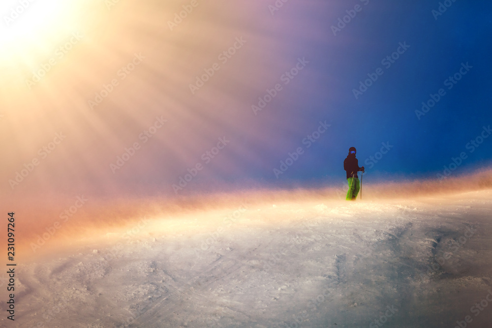 Skier silhouette sunset ride in the mountains