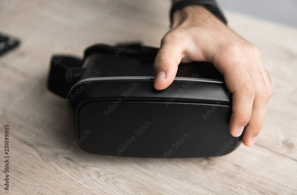 VR virtual reality glasses on a table with a man hand. VR virtual reality glasses on a table with a man hand.