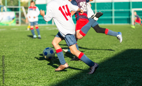 football teams - boys in red  blue  white sportswear play soccer on the green field. boys dribbling. dribbling skills. Team game  training  active lifestyle  hobby  sport for kids concept