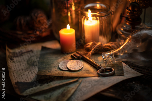 Old coins, key, burning candle and vintage letters
