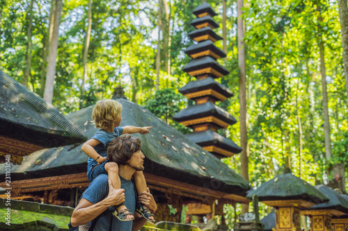 Dad and son travelers discovering Ubud forest in Monkey forest, Bali Indonesia. Traveling with children concept photo