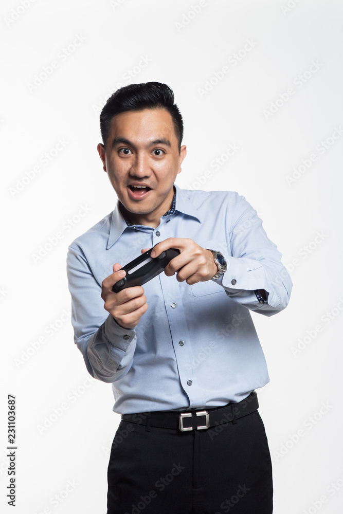 Asian man in work cloth playing console game Asian man in work cloth playing console game