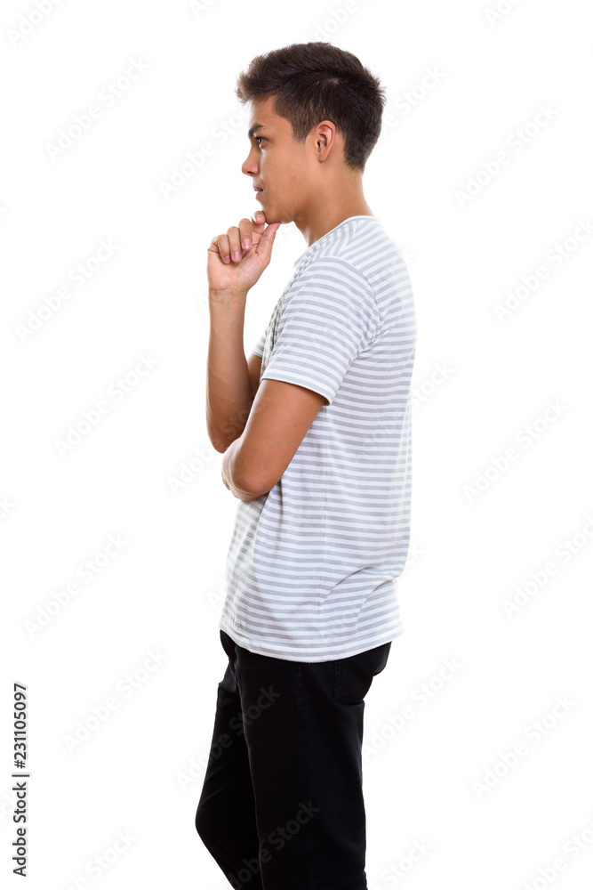 Profile view of young handsome man standing while thinking Profile view of young handsome man standing while thinking