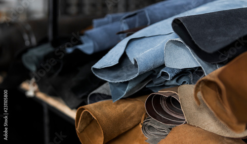 Different pieces of leather in a rolls. The pieces of the colored leathers. Rolls of blue and black leather. Raw materials for manufacture of bags, shoes, clothing and accessories.