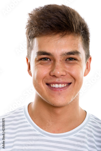 Face of young happy man smiling while looking at camera