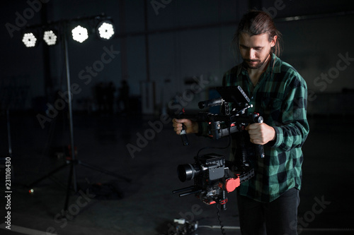 Professional videographer holding camera on 3-axis gimbal. Videographer using steadicam. Pro equipment helps to make high quality video without shaking.