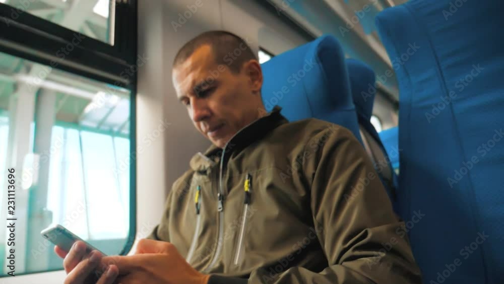 blurred background. unknown middle-aged man smartphone in the subway writes sms to message social media messenger. man in railway train . lifestyle man traveler in train concept travel blurred background. unknown middle-aged man smartphone in the subway writes sms to message social media messenger. man in railway train . lifestyle man traveler in train concept travel