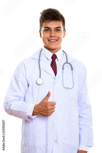 Studio shot of young happy man doctor smiling while giving thumb © Ranta Images