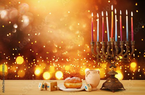 image of jewish holiday Hanukkah background with menorah (traditional candelabra) and candles over glitter shiny background.