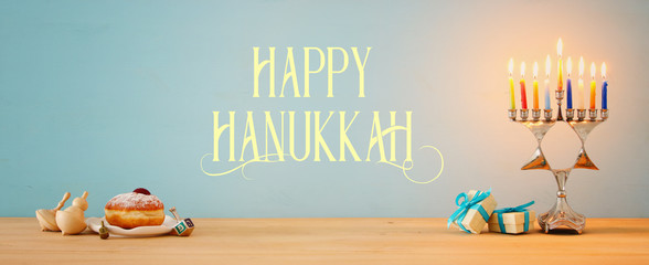 Banner of jewish holiday Hanukkah background with traditional spinnig top, menorah (traditional candelabra) and burning candles