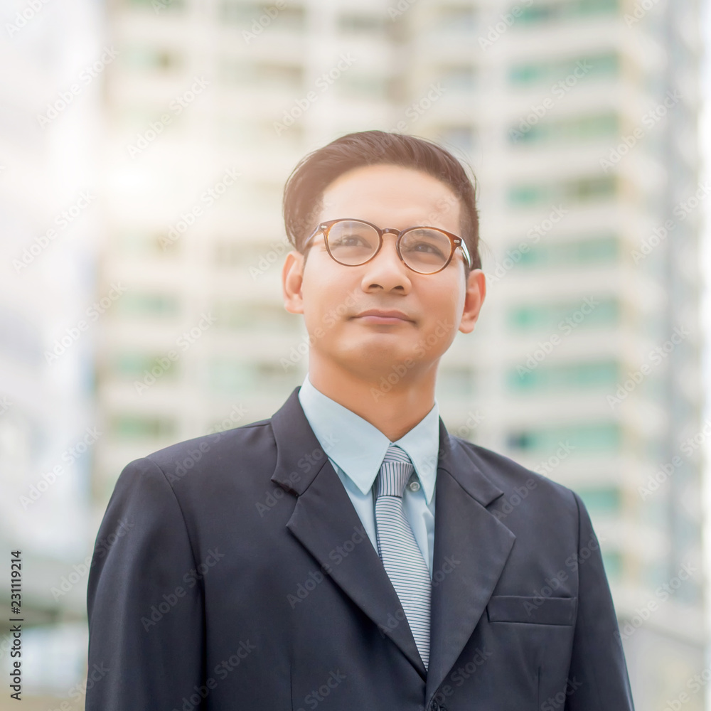 Asia young business man in front of the modern building in downtown .Concept of young business people Asia young business man in front of the modern building in downtown .Concept of young business people