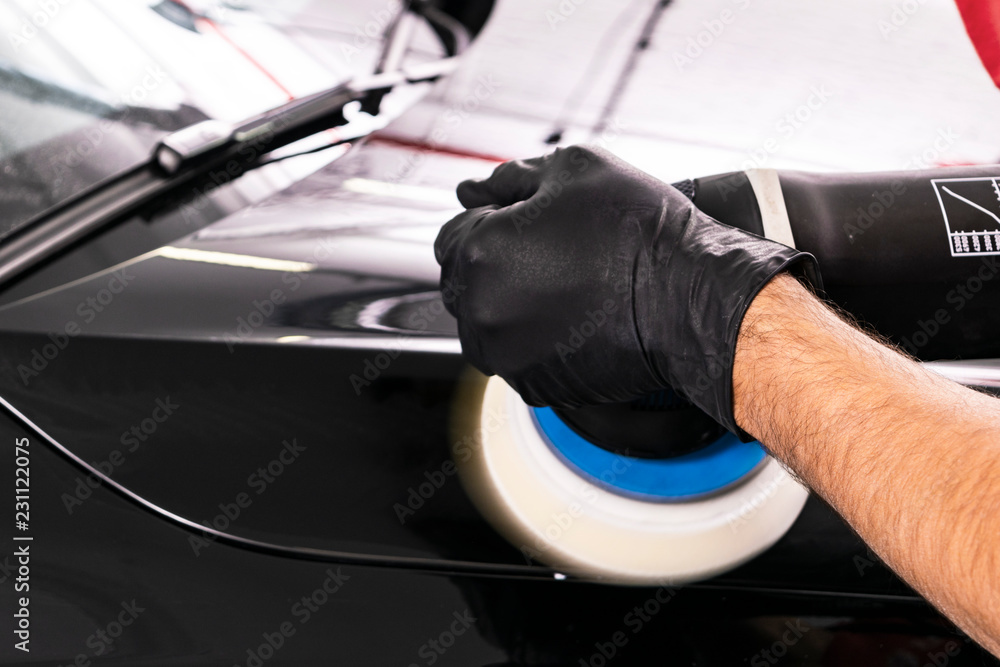 Car polish wax worker hands applying protective tape before