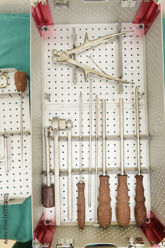 Fototapeta Naklejka Na Ścianę i Meble -  Detail shot of steralized surgery instruments with a hand grabbing a tool