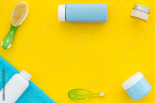 Children's personal care kit. Bath accessories with teeth brush on yellow background top view spacefor text photo