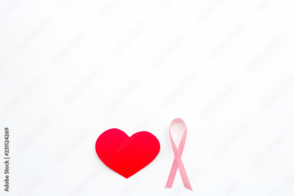 Breast cancer. Mammalogy concept. Symbolic pink ribbon near heart sign on white background top view copy space