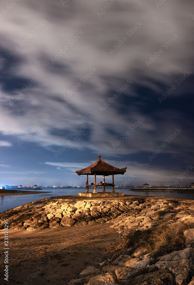 Pavilion on rock jetty with cloudy in sanur beach
