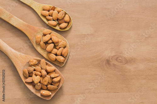 Fényképezés Almonds on wooden spoon.