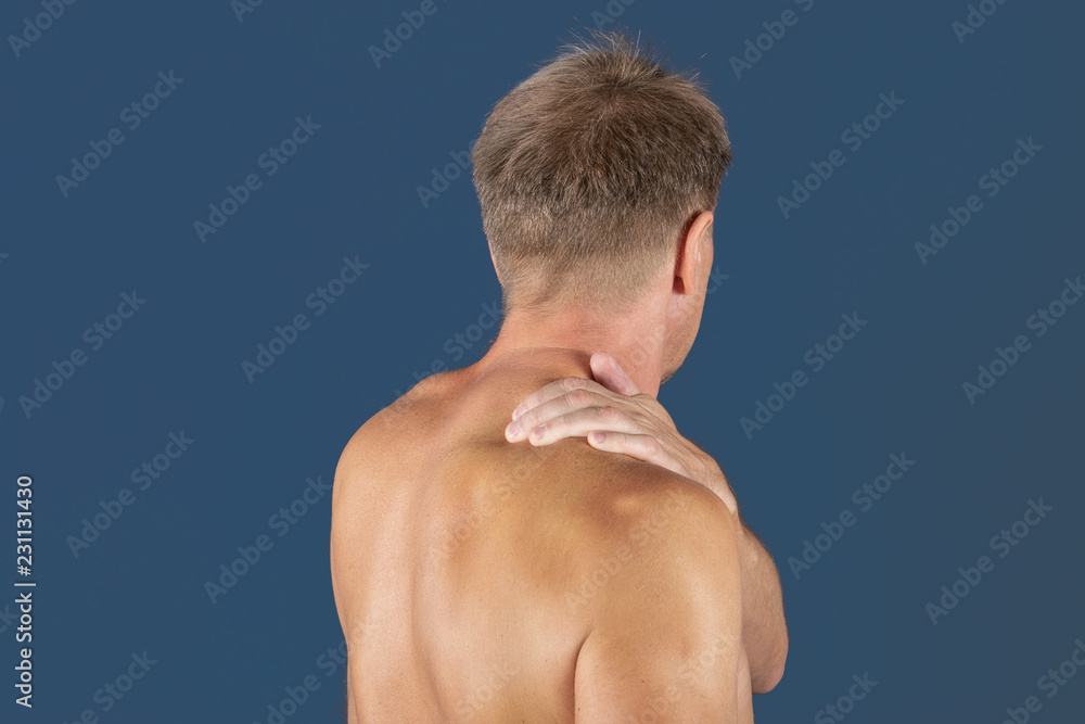 Man holding his sore shoulder trying to relieve pain. Health problems