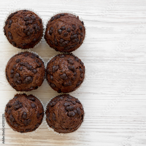 Chocolate muffins on white wooden table, top view. Flat lay, overhead, from above. Copy space.