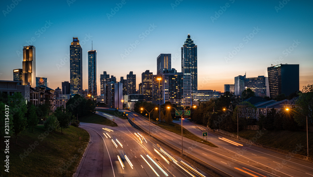 Fototapeta premium Evening car traffic flowing against city skyline