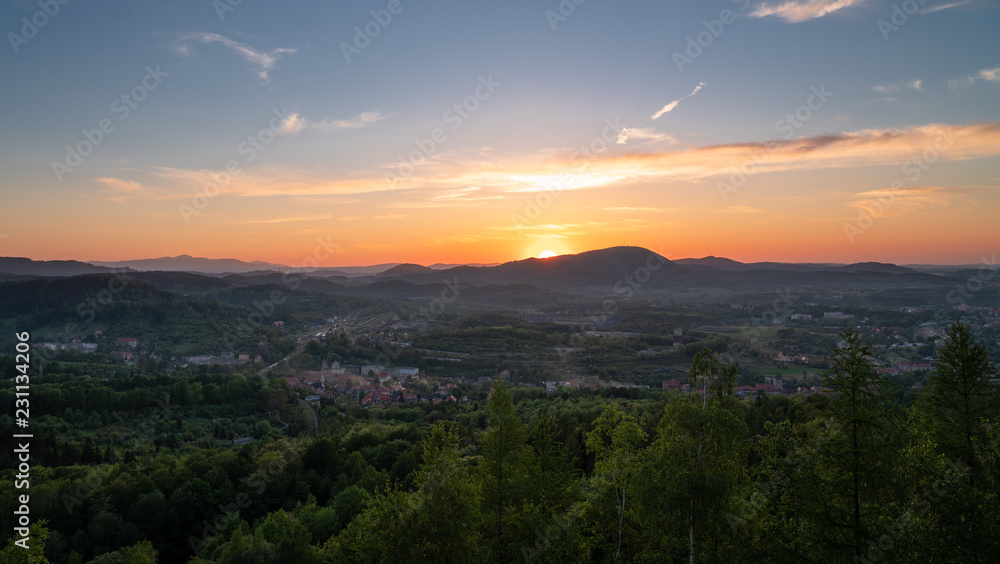 Panorama view of a city and summer sunset captured from a hill