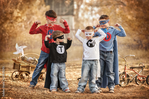Obraz na plátně Four boys play a superhero in the playground