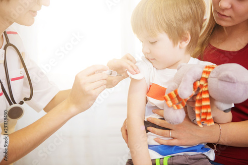 A doctor giving a child an injection at home