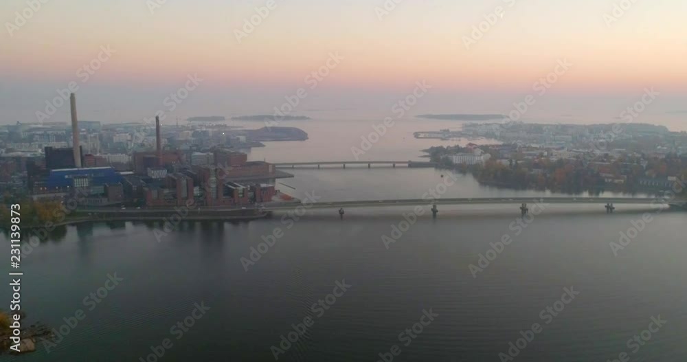 Helsinki seascape, C4k aerial, drone shot, over the sea, towards lapinlahti bridge, lauttasaari and ruoholahti, on a sunny and misty, autumn evening dusk, in Helsinki, Finland Helsinki seascape, C4k aerial, drone shot, over the sea, towards lapinlahti bridge, lauttasaari and ruoholahti, on a sunny and misty, autumn evening dusk, in Helsinki, Finland
