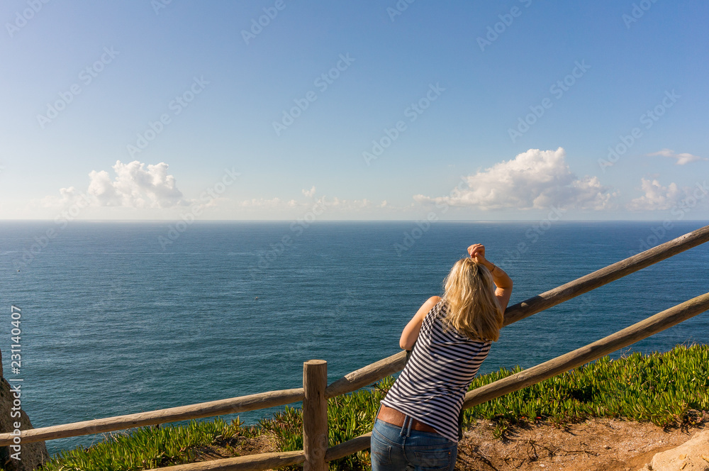 Femme pensive sur la côte regarde la mer 