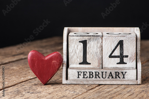 Wooden calendar show of February 14. Red heart.