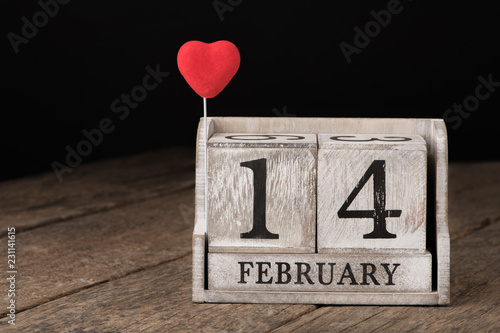 Wooden calendar show of February 14. Red heart.