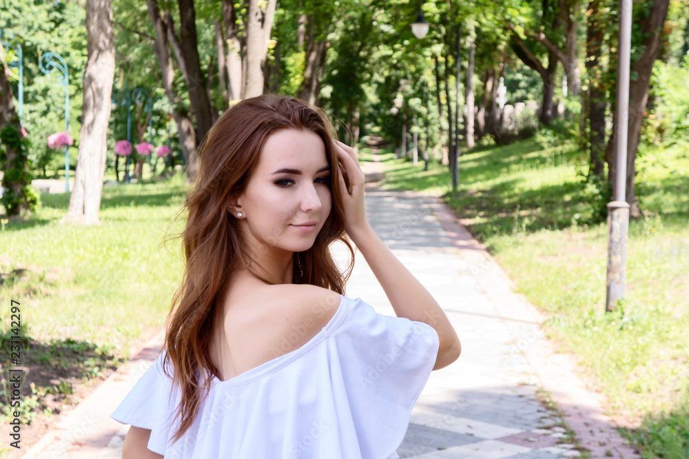 Young girl in a white dress in the park.