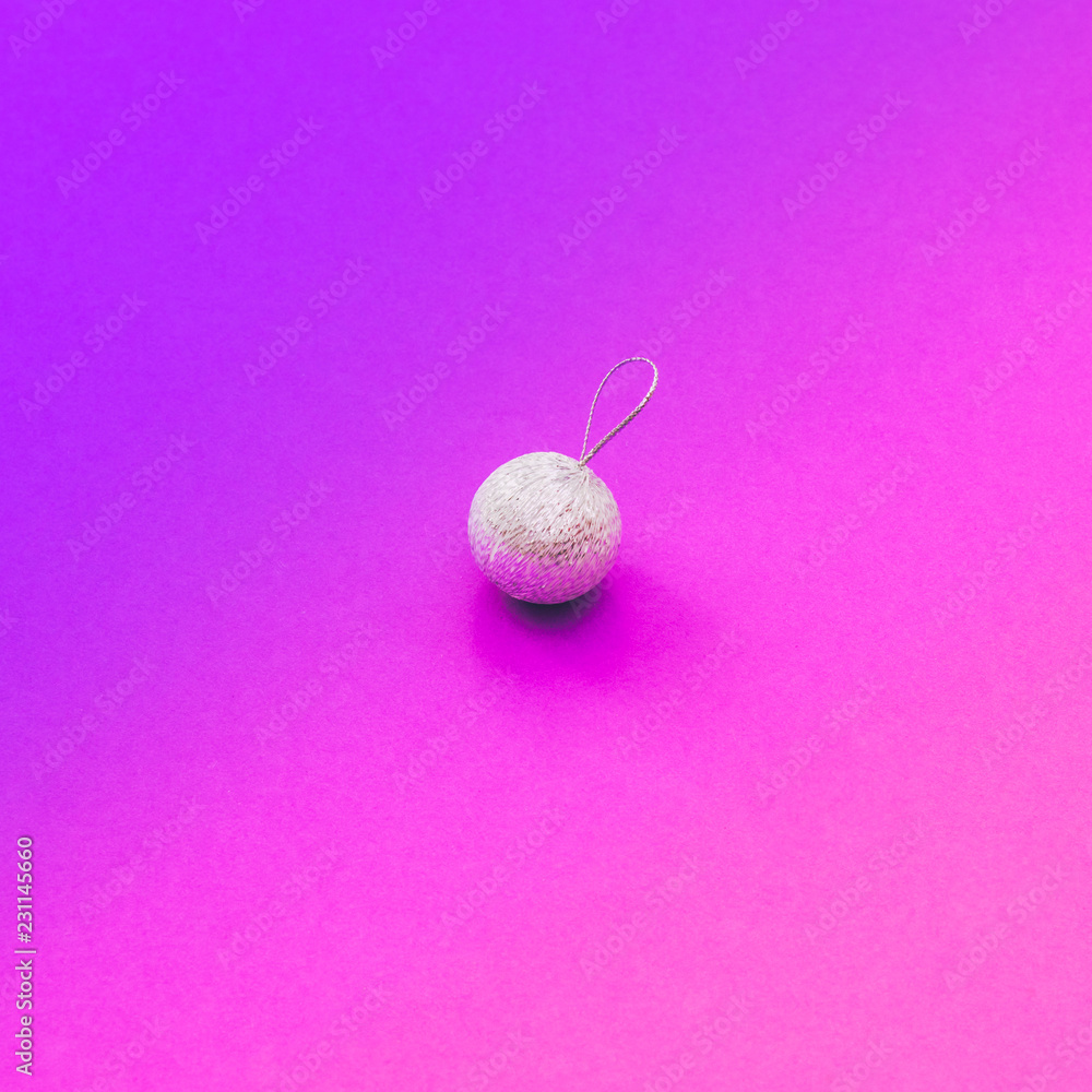 Creative Christmas shiny silver ball decoration on purple and pink gradient holographic background. Minimal flat lay concept. Creative Christmas shiny silver ball decoration on purple and pink gradient holographic background. Minimal flat lay concept.
