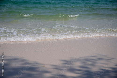 Clear blue sea water on white sand beach. Tropical seaside photo. Sea beach view in sunny day. Seashore landscape.