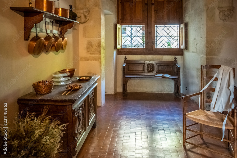 Kitchen in a medieval castle with kitchenware, furniture and food on