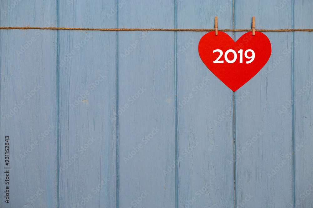 Red paper heart with 2019 happy new year text on blue wooden background, banner with copy space for text Red paper heart with 2019 happy new year text on blue wooden background, banner with copy space for text
